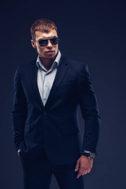 Fashion young businessman black suit on dark background - Фото, зображення