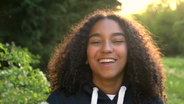 4K video clip de hermosa feliz mixta raza afroamericana chica adolescente o mujer joven riendo, sonriendo y soplando un diente de león al atardecer o al amanecer
 - Metraje, vídeo