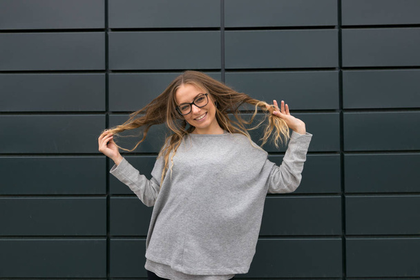Large portrait of a girl with glasses on a gray background - Photo, Image