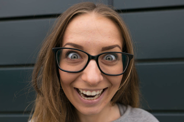 Большой портрет девушки в очках на сером фоне
 - Фото, изображение