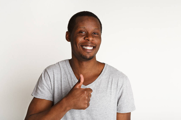 Счастливый черный мужчина показывает большой палец вверх жестом, студийный снимок
 - Фото, изображение