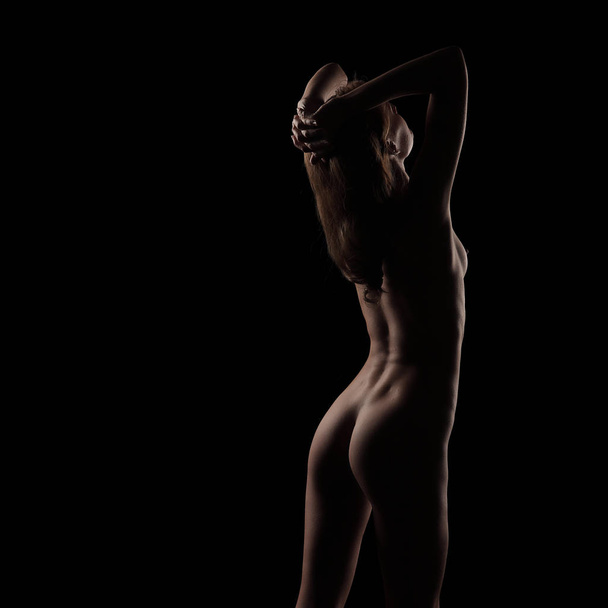 Sexy nude woman body over black, back shot with arms on head - Foto, Bild