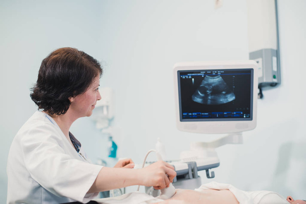 Arzt zeigt Schwangeren Baby-Ultraschallbild am Computer - Foto, Bild