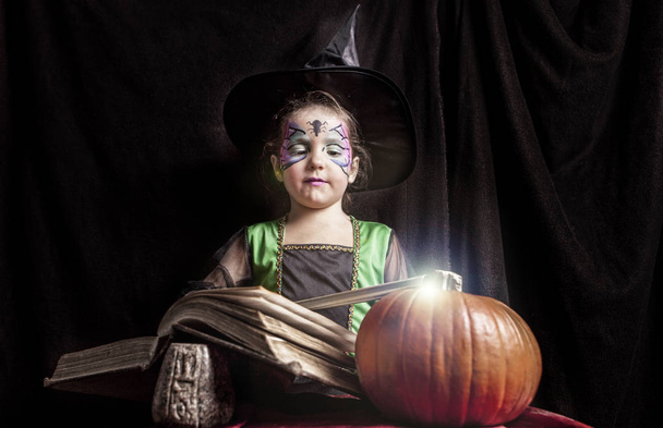 Little witch reads the Book of Spells - Foto, imagen