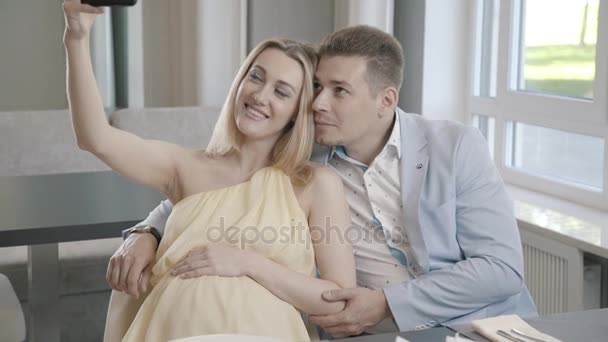 A pregnant woman and her husband in a light suit are photographed - Video, Çekim