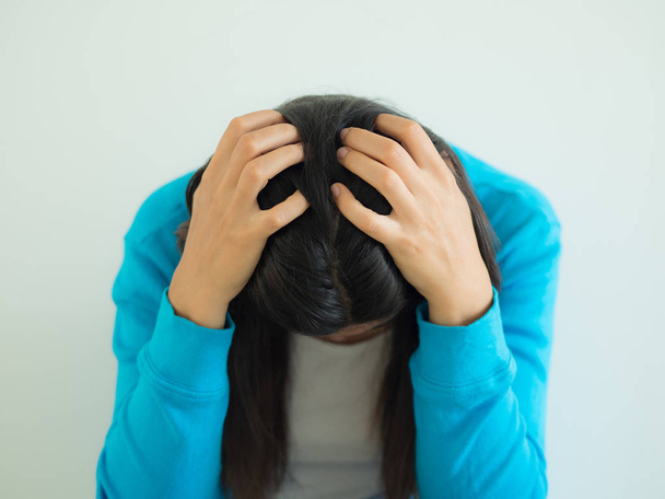 eine Frau tief in Gedanken oder mit Kopfschmerzen, vor einem dunklen Hintergrund Raum für Copyspace - Foto, Bild
