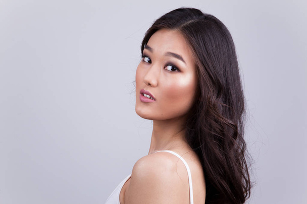 Portrait of a beautiful asian woman with makeup and light curls. - 写真・画像