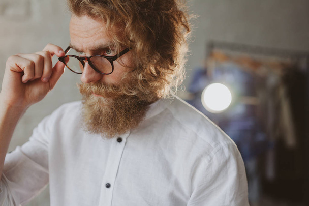 Bebaarde man met bril poseren in studio - Foto, afbeelding