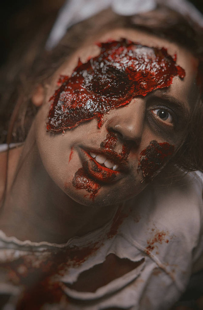 de foto van het meisje in zombie make-up bedekt met bloed - Foto, afbeelding