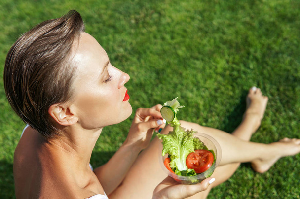 Portrait of attractive caucasian smiling woman eating salad  - Photo, Image