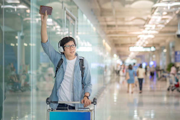 jovem asiático homem acenando sua mão no aeroporto
 - Foto, Imagem