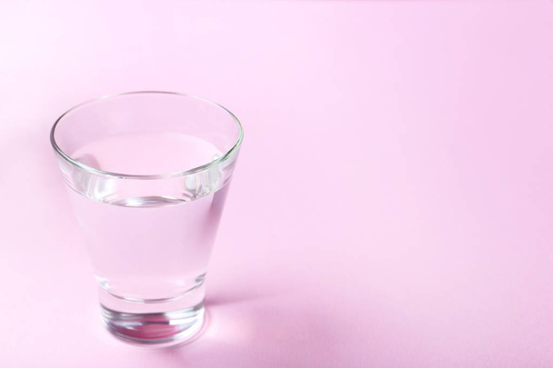 Glass with water on pink background - Foto, Imagem