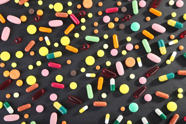 Different colorful pills on black background - Zdjęcie, obraz