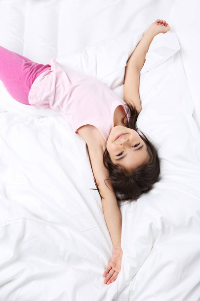 Beautiful little girl sleeping in bed - Фото, изображение