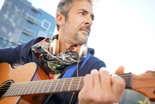 Mature trendy guy playing the guitar  - Photo, Image