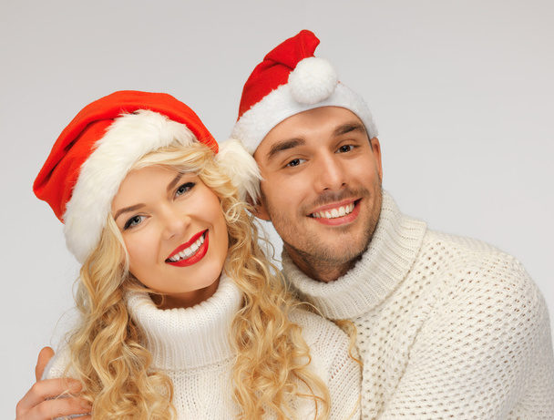 Family couple in sweaters and santa's hats - Φωτογραφία, εικόνα