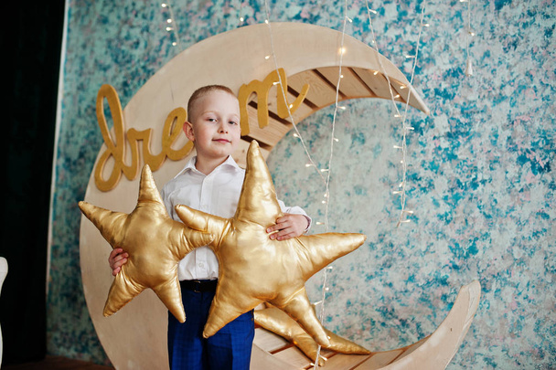 Cute small handsome boy posing on artificial moon decoration whi - Foto, Bild