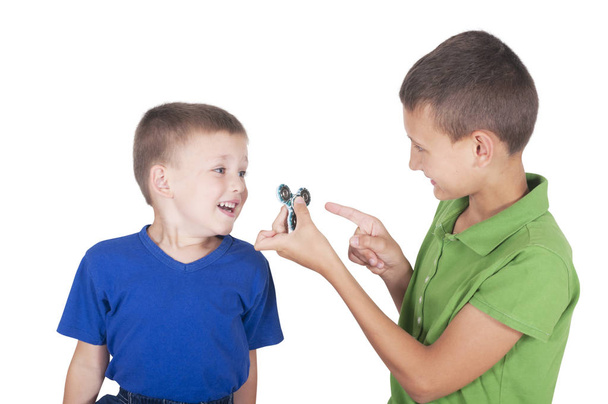 Брат показывает младшему игрушечный спиннер
 - Фото, изображение