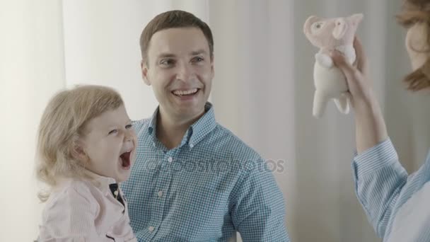Mom is playing with soft toy, girl joyfully screams and rejoices. - Video, Çekim