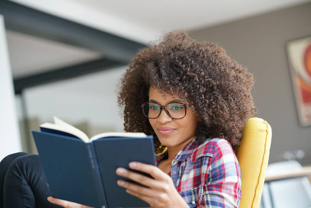 girl with eyeglasses reading book  - Фото, изображение