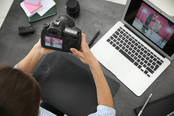 Female photographer with camera and laptop in office - Foto, Bild