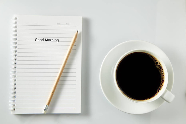 weiße Tasse Kaffee am Morgen auf Holztisch mit Notizbuch - Foto, Bild