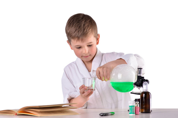 Επιστήμη αγόρι χύνει υγρό από φιάλη στο γυαλί - Φωτογραφία, εικόνα
