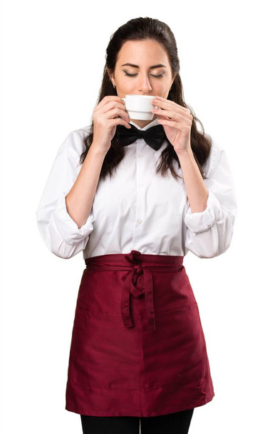 Young beautiful waitress holding a cup of coffee - Fotoğraf, Görsel