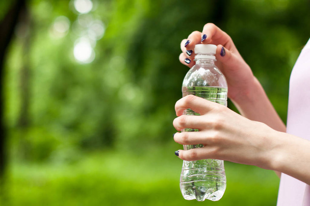 Close-up garrafa de água de plástico na mão da mulher
 - Foto, Imagem