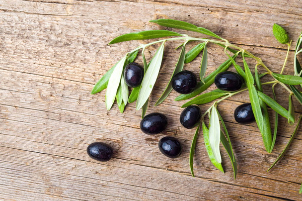 Tummat oliivit puupöydällä
 - Valokuva, kuva