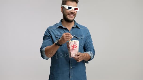 guy wearing 3D glasses eating popcorn and laughing - Filmagem, Vídeo