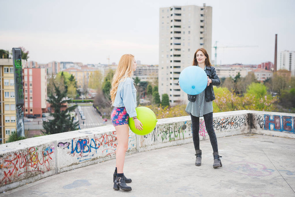 girls playing with balloons in city - Photo, Image