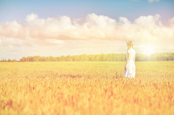happy young woman in flower wreath on cereal field - Foto, immagini