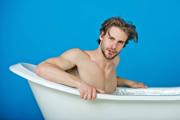 relax and hygiene, man with muscular body in white bathtub - Foto, Imagem