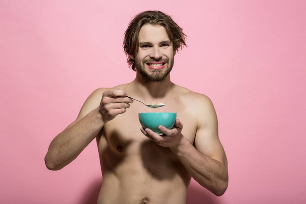 happy muscular man eating morning breakfast - Фото, изображение