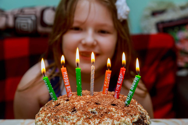 Μικρό κορίτσι φυσάει κεριά γενεθλίων τούρτα με κεριά - Φωτογραφία, εικόνα