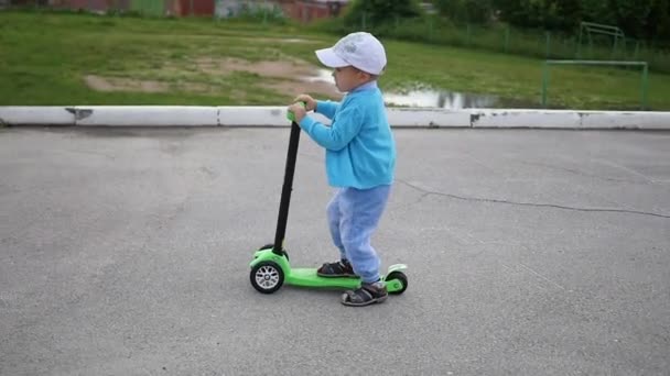un niño feliz monta su scooter en el Park.Fun al aire libre
 - Metraje, vídeo