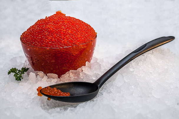 Red caviar in a large spoon on ice - Photo, Image