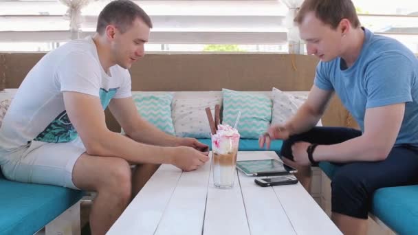 Los hombres hablan en un café y trabajan con tabletas
 - Imágenes, Vídeo