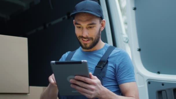 Smiling Delivery Man with a Tablet Checks His Cargo Count. - Filmati, video