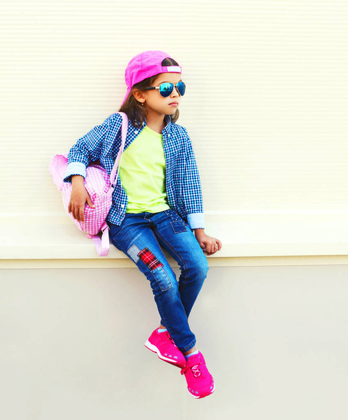 Fashion little girl child wearing a baseball cap and backpack in - Фото, зображення