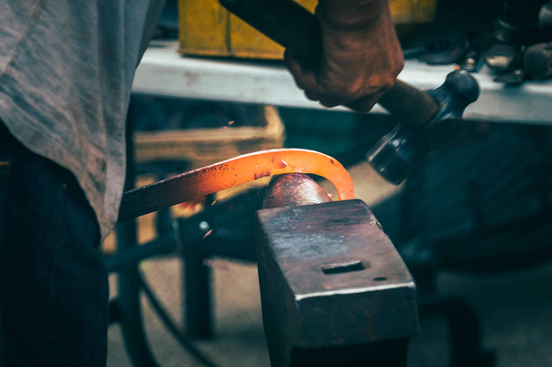 A blacksmith hammering hot iron  - Photo, Image