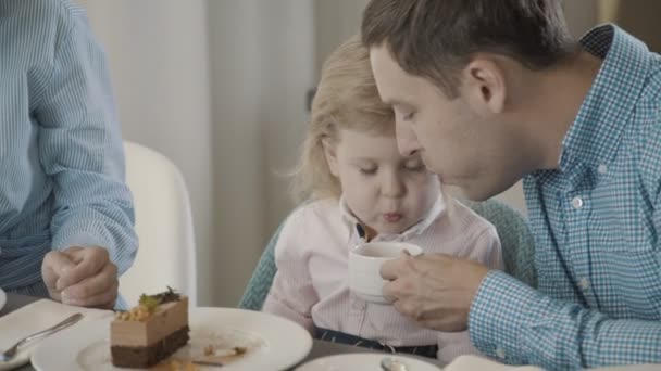 Dad and daughter blow together for hot tea to cool it. Family - Imágenes, Vídeo