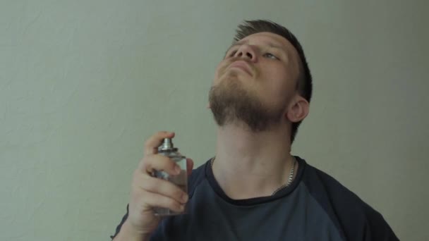 Man sprinkling perfume on his neck, than sniffing scent. - Materiał filmowy, wideo