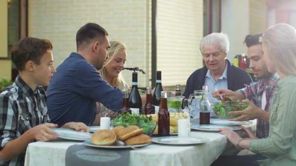 Grupo de pessoas de raça mista se divertindo, se comunicando e comendo no jantar de família ao ar livre
 - Filmagem, Vídeo