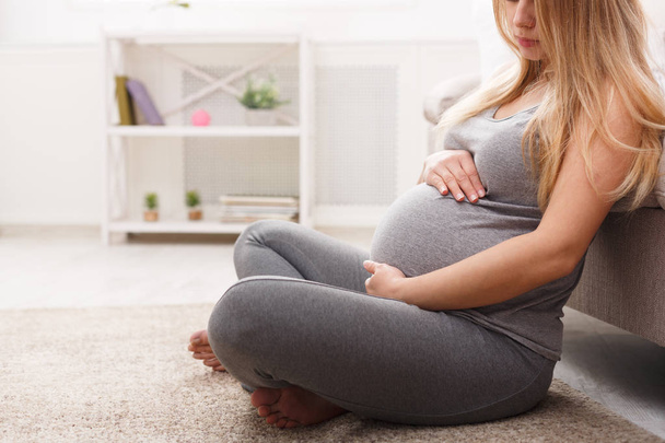 Femme enceinte méconnaissable caressant son ventre
 - Photo, image