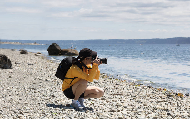 Mujer fotógrafa tomando fotos alrededor del lago plácido durante un
 - Foto, Imagen