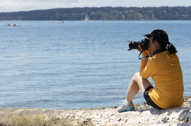 Mujer fotógrafa tomando fotos de un lago tranquilo durante el verano
 - Foto, Imagen
