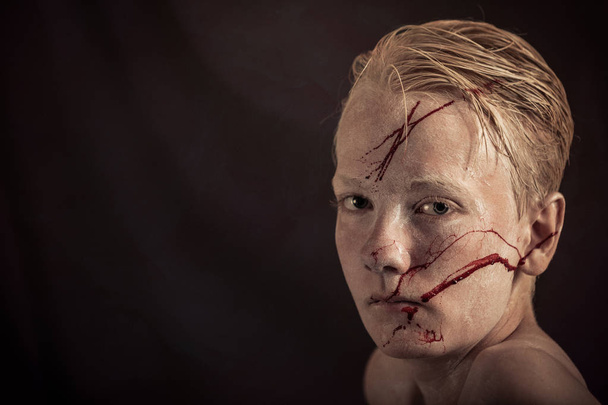 Хлопчик з кров'ю розкиданий по його обличчю дивиться
 - Фото, зображення