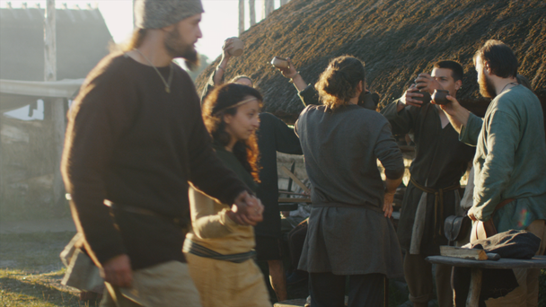 Vestido con ropa medieval Grupo de personas bebiendo, bailando y celebrando. Life of Civil People at the Village (en inglés). Representación medieval
. - Metraje, vídeo